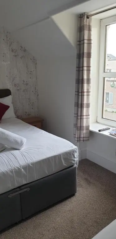 a bedroom with a bed and a window at Dunskaith Villa in Inverness