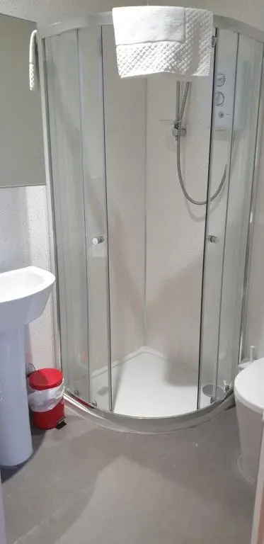 a shower with a glass door in a bathroom at Dunskaith Villa in Inverness