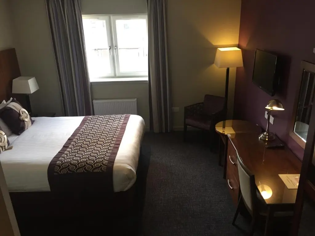 a hotel room with a bed and a window at Buchan Hotel in Ellon