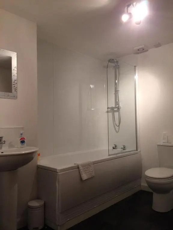 a bathroom with a tub and a toilet and a shower at Eastgate Apartment in Inverness