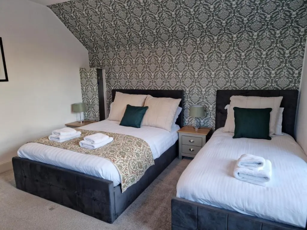 two beds sitting next to each other in a bedroom at Strathardle Lodge in Kirkmichael
