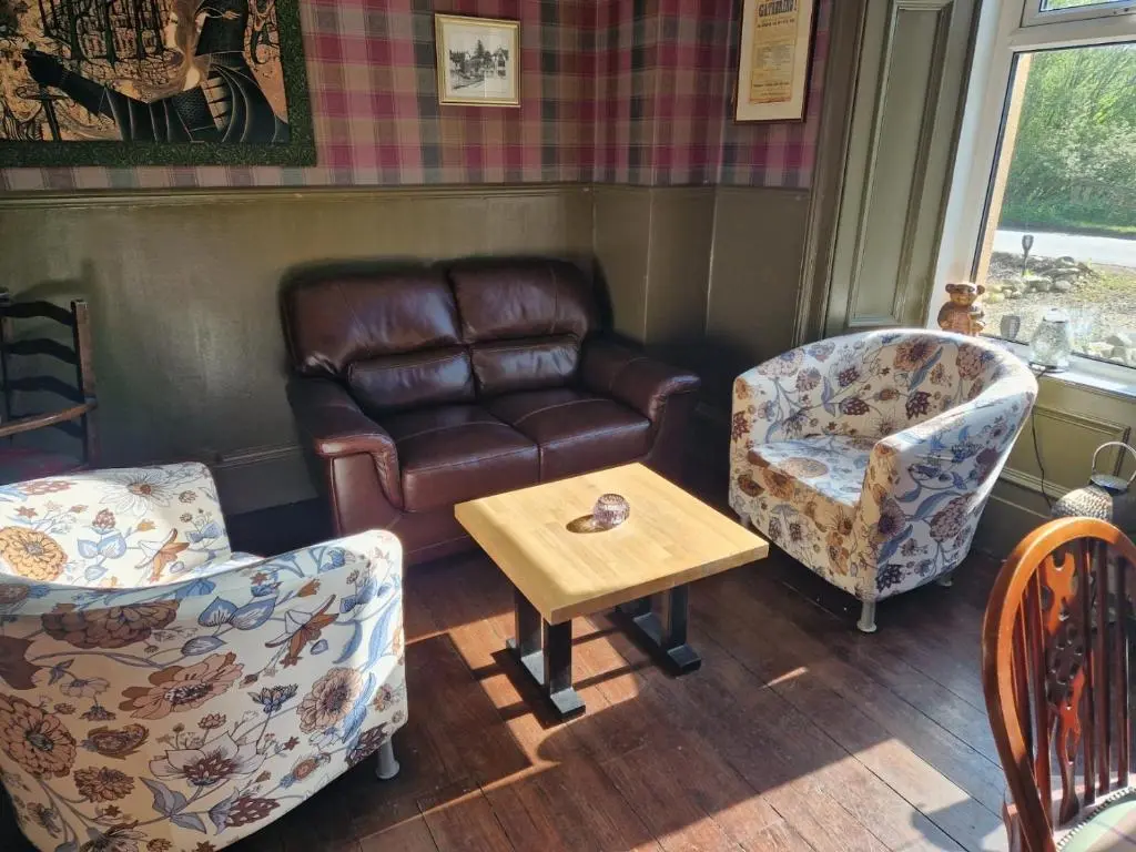 a living room with a couch and two chairs and a table at Strathardle Lodge in Kirkmichael