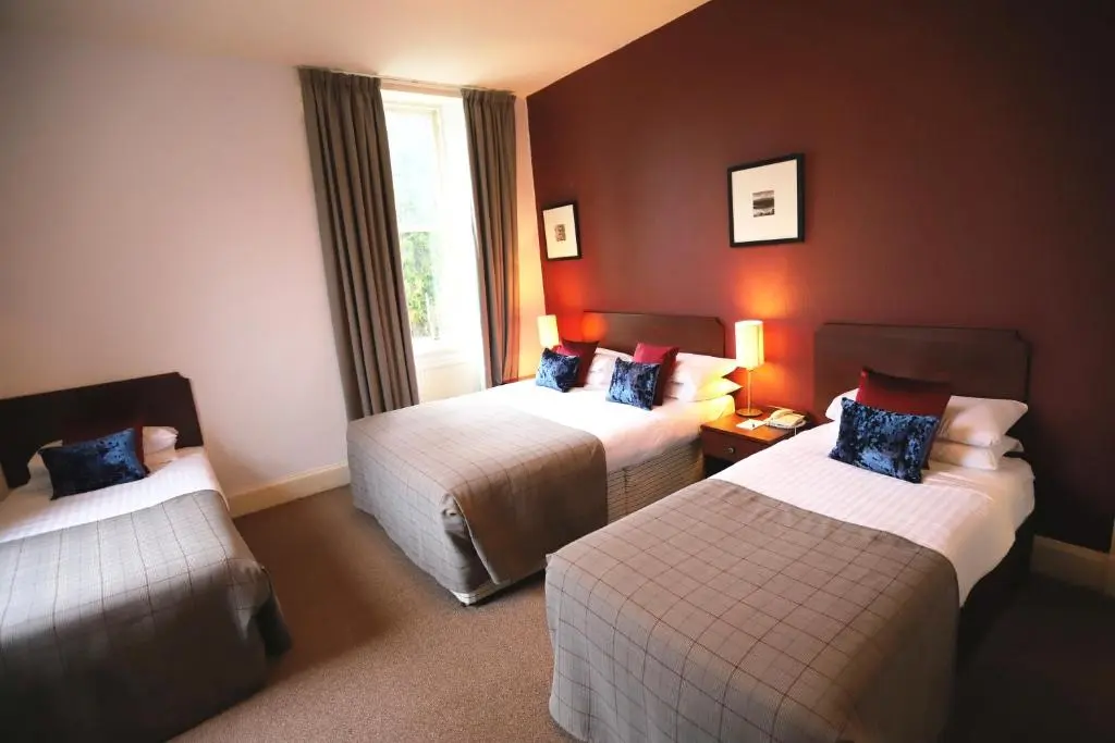 a hotel room with two beds and a window at Ben Wyvis Hotel in Strathpeffer
