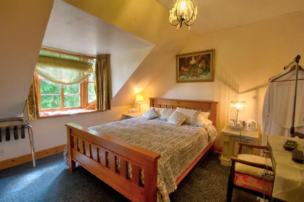 a bedroom with a large bed and a window at Glasdair in Inverness