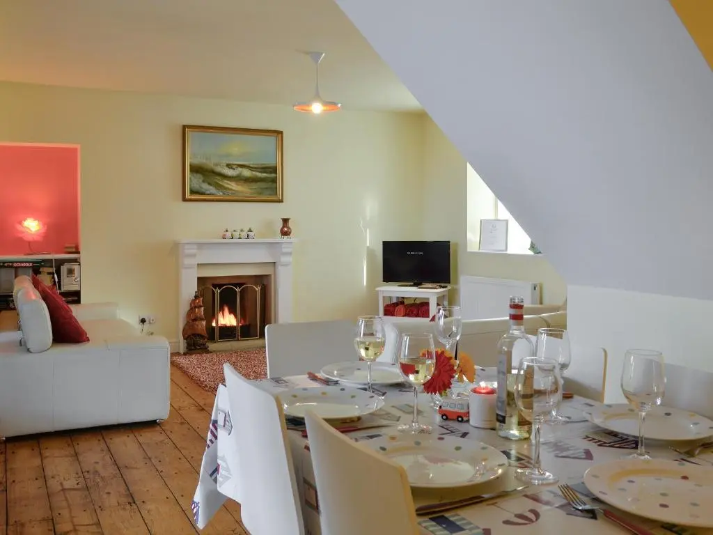 a dining room with a table and a fireplace at Salty Dog in Findochty