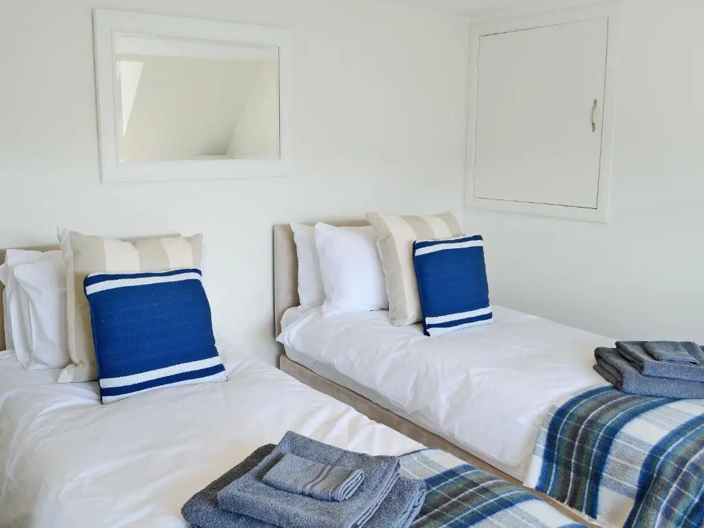 two beds sitting next to each other in a room at The Wee Hoose in Achnahanat