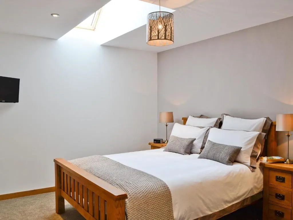 a bedroom with a bed with white sheets and pillows at Longcroft Dairy in Oyne