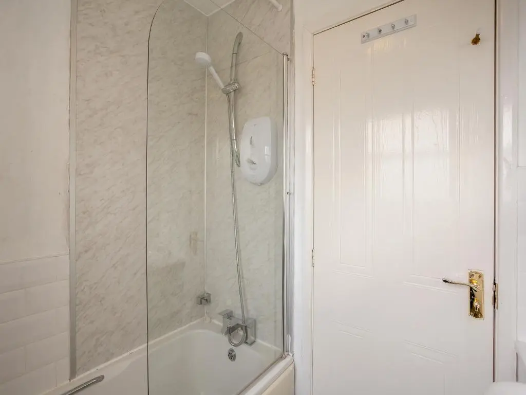 a bathroom with a shower with a glass door at Cairnie View in Aviemore