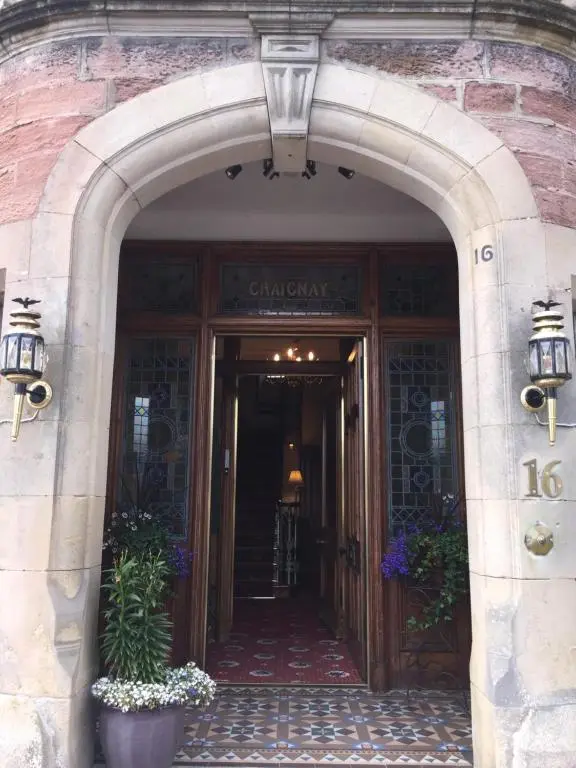 an entrance to a building with an archway and flowers at Craignay Guest House in Inverness