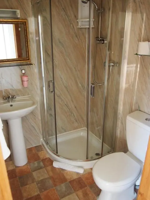 a bathroom with a shower and a toilet and a sink at Craignay Guest House in Inverness