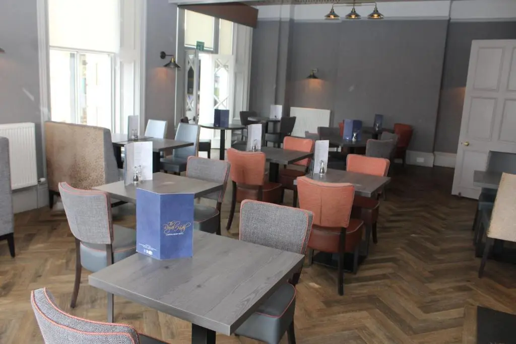 a restaurant with tables and chairs in a room at The Royal Hotel Elgin in Elgin