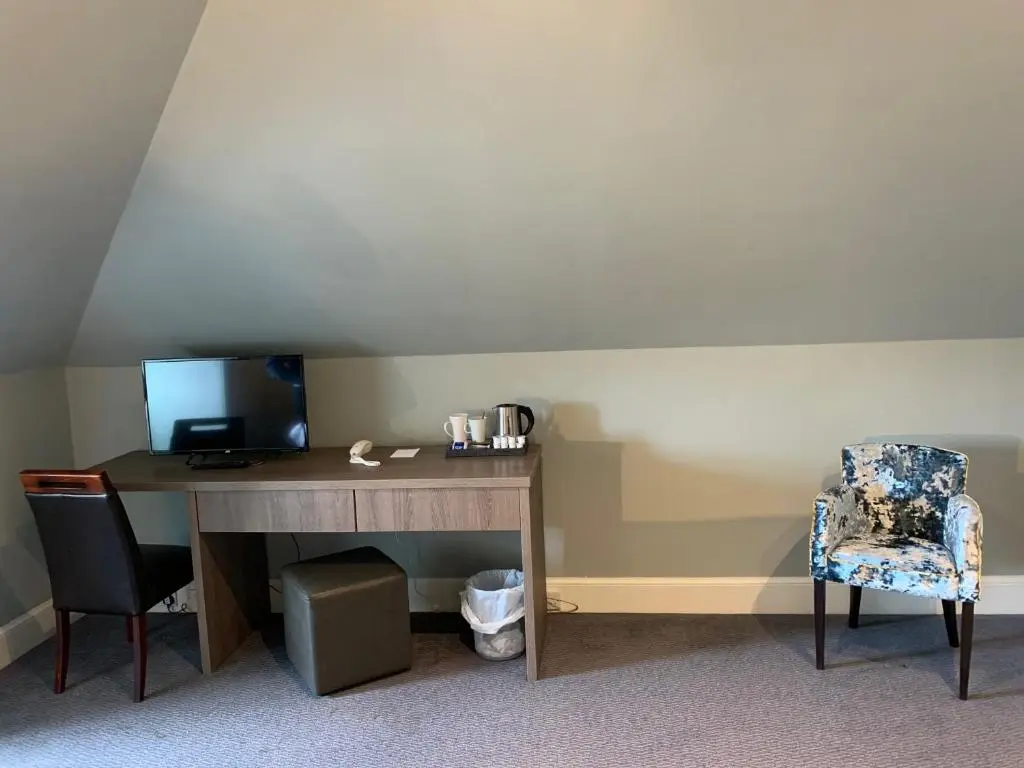 a desk with a computer and a chair in a room at The Royal Hotel Elgin in Elgin