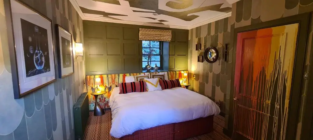a bedroom with a bed with white sheets and a window at The Glenmorangie House in Tain