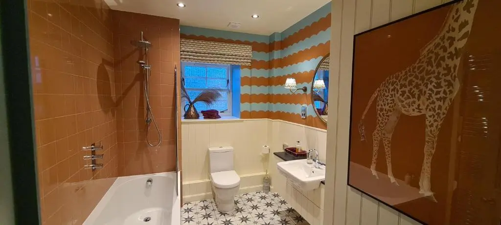 a bathroom with a giraffe painted on the wall at The Glenmorangie House in Tain