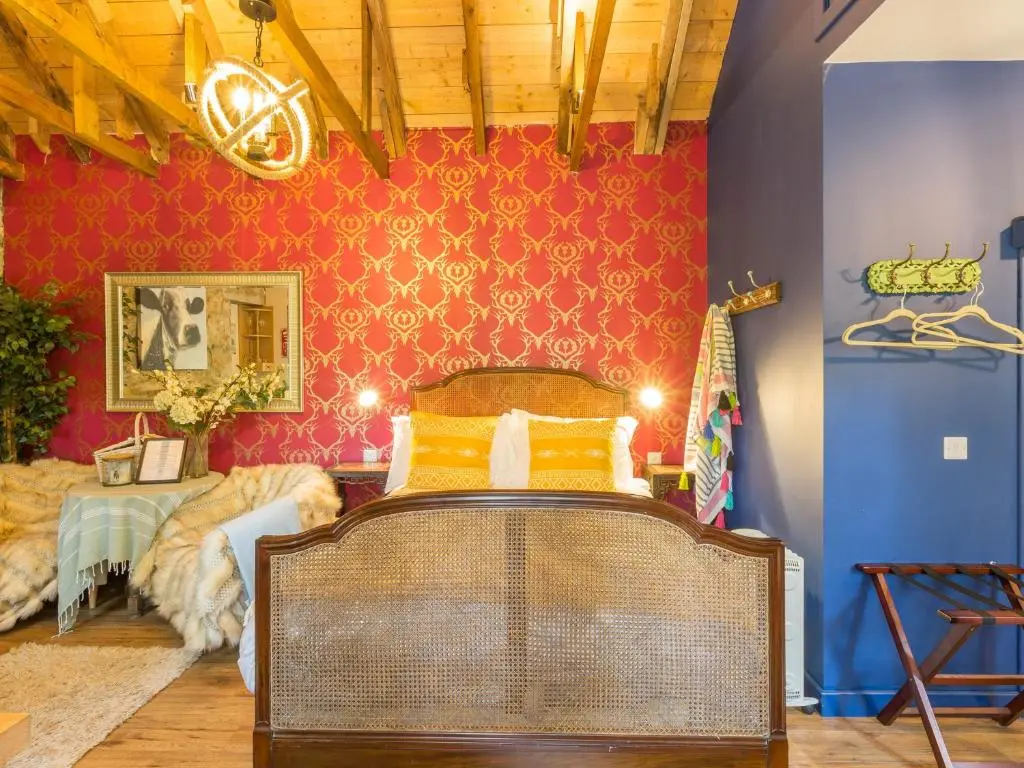a room with a bed and a red wall at Glamping Bothie in Inverurie