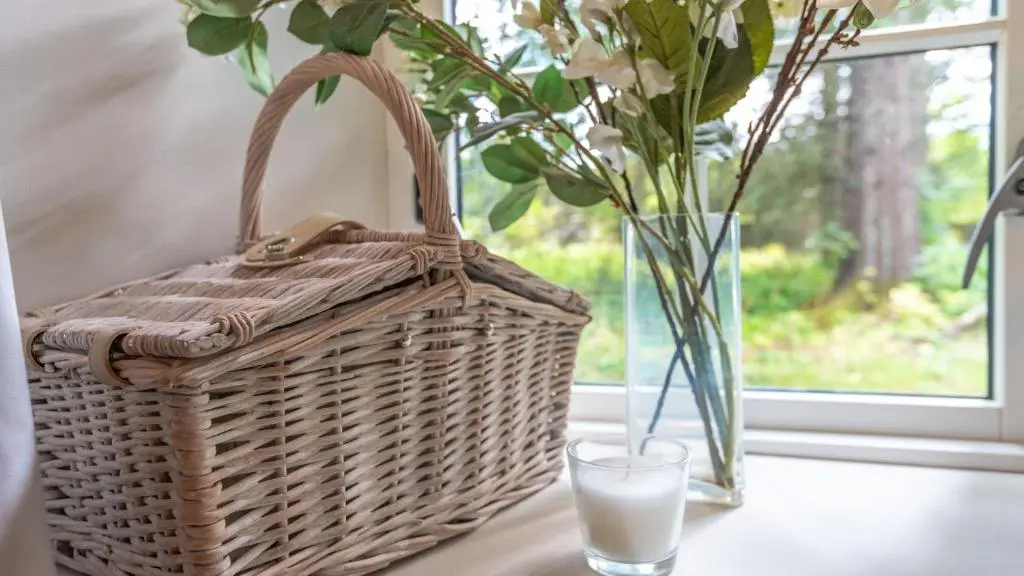 a basket and a glass of milk and a vase with flowers at Glamping Bothie in Inverurie