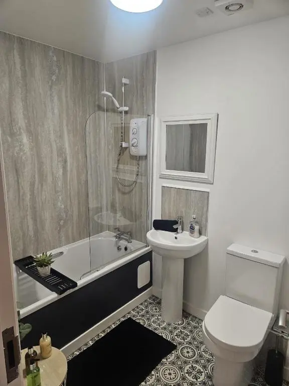 a bathroom with a tub and a toilet and a sink at LANGLEY APARTMENT free parking outside between 6 pm and 8 am Secure parking 2 min walk Ideal for TRADES AND TOURISTS WANTING GREAT LOCATION in Inverness
