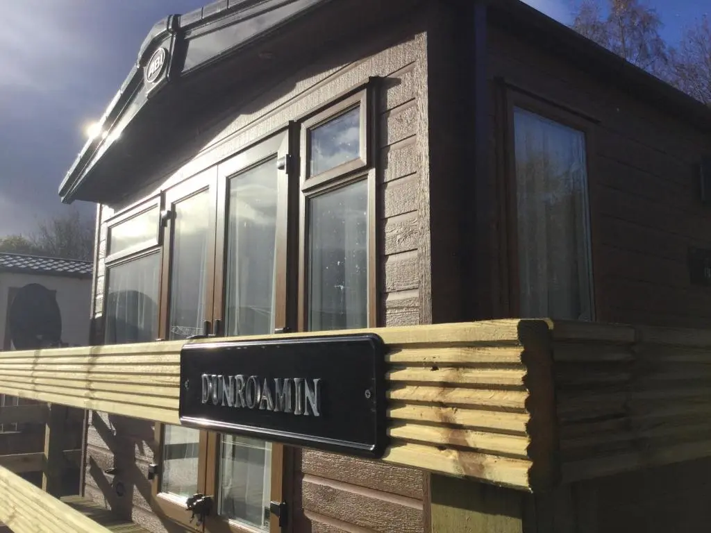 a sign on the side of a tiny house at Dunroamin Lodge in Aviemore