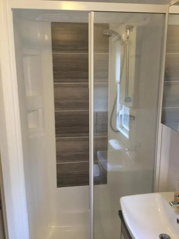 a bathroom with a shower and a sink at Dunroamin Lodge in Aviemore