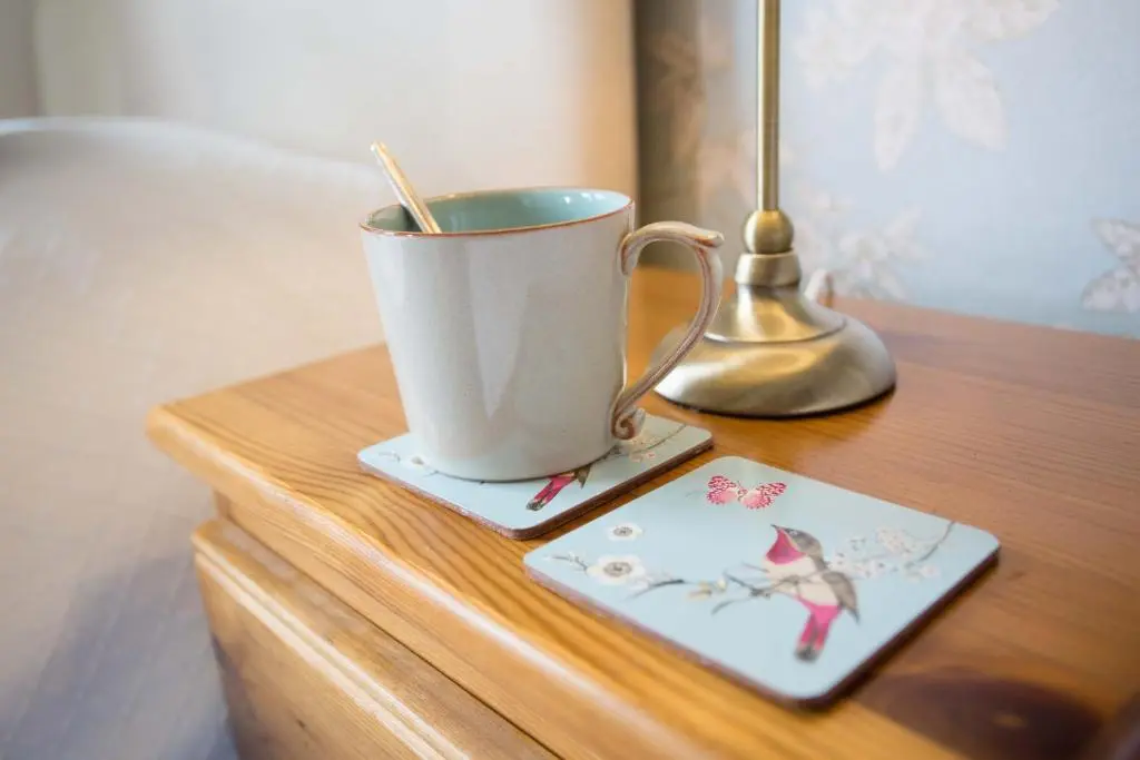 a coffee cup on a wooden table with a lamp at Leanach Farm in Inverness