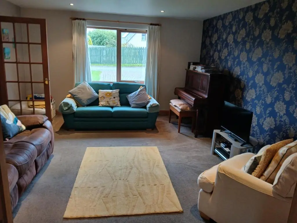 a living room with a couch and a piano at Holiday House Kinveachy in Aviemore