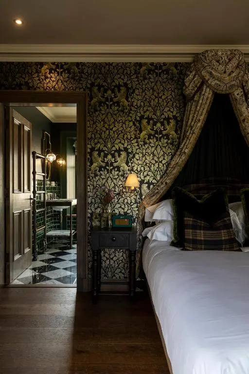 a bedroom with a bed and a wall with wallpaper at Kildrummy Inn in Kildrummy