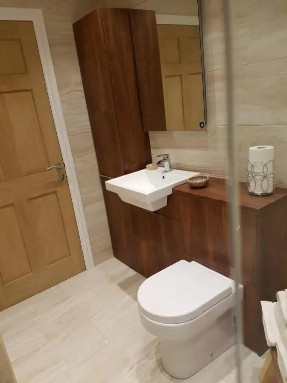 a bathroom with a white toilet and a sink at The Little House by the Ness in Inverness