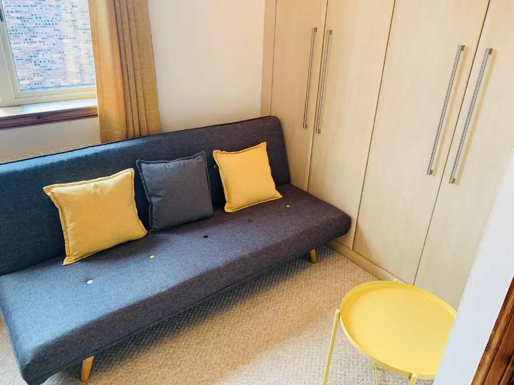 a blue couch with two yellow pillows in a room at Drumdale Bed and Breakfast in Inverness