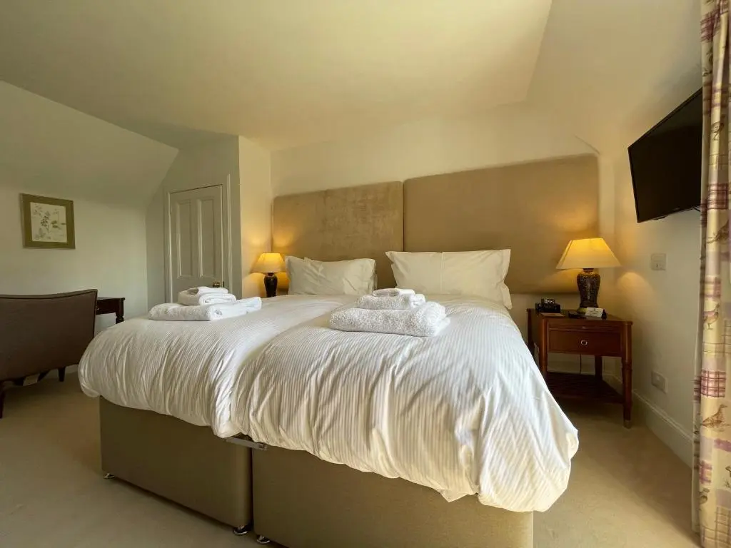 a bedroom with a large bed with two towels on it at Balloan House in Dornoch