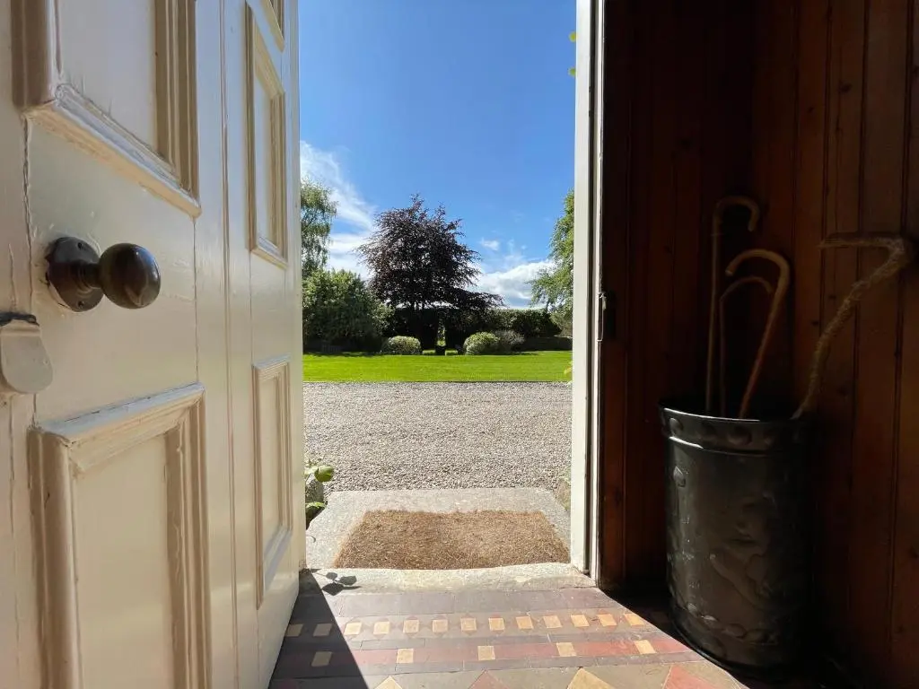 an open door with a view of a yard at Balloan House in Dornoch