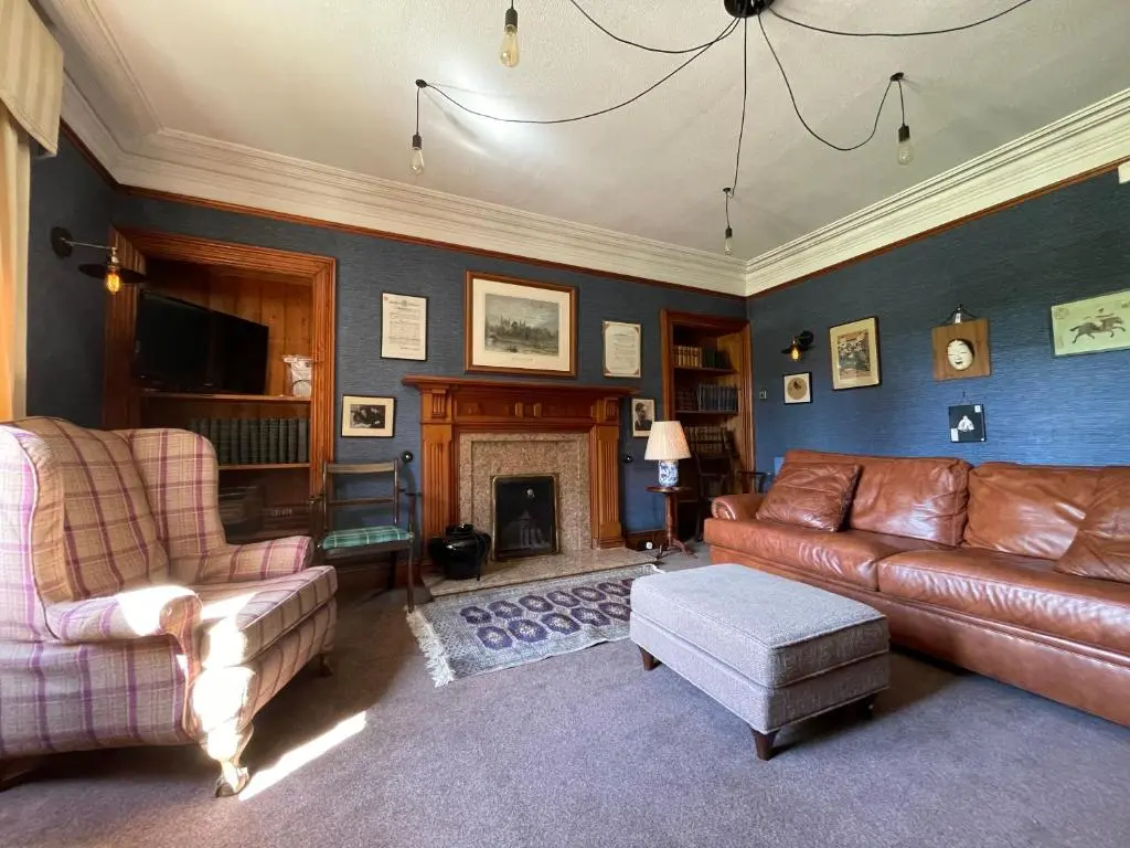 a living room with a couch and a fireplace at Balloan House in Dornoch