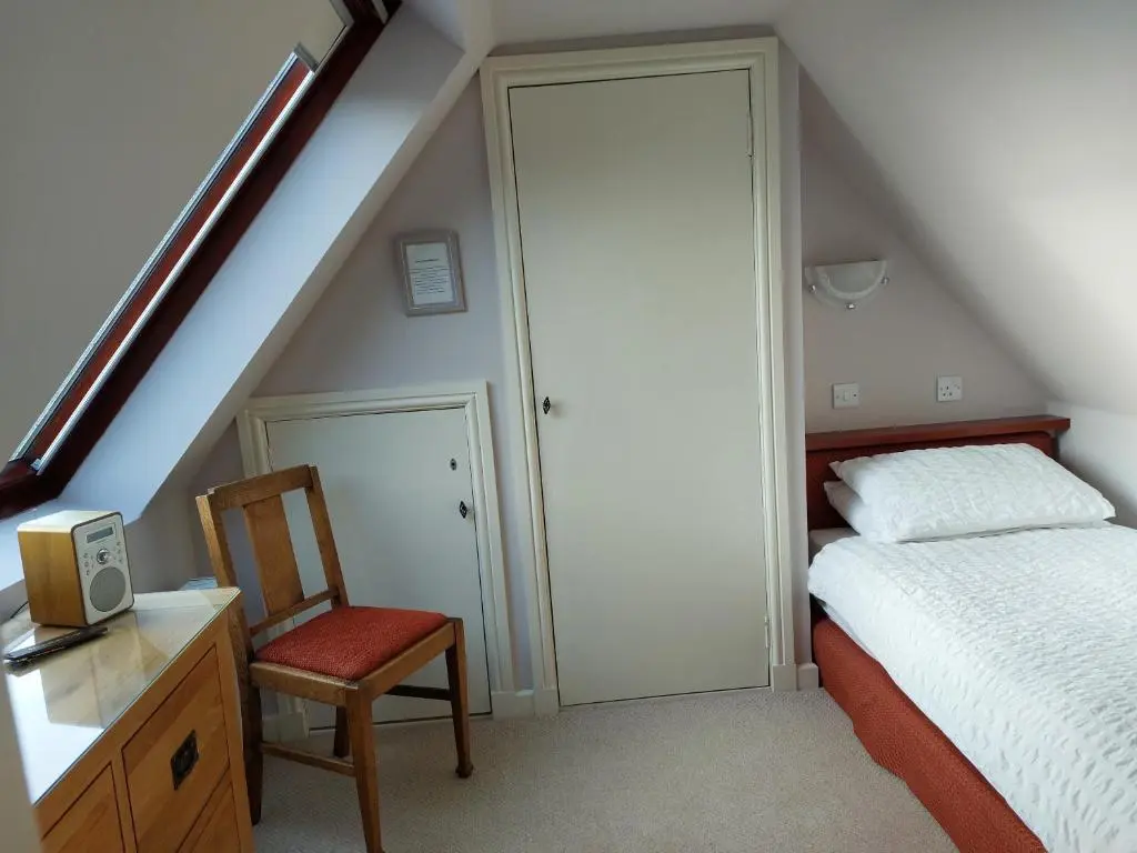 a bedroom with a bed and a chair and a desk at Chapelhill Croft in Keith