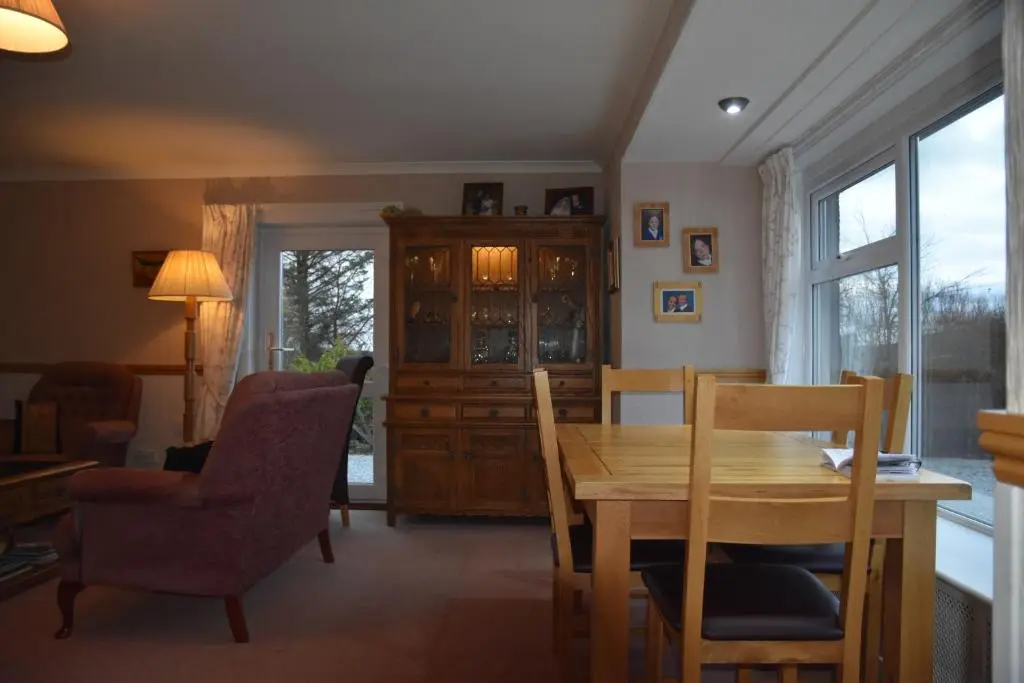 a dining room with a wooden table and chairs at Chapelhill Croft in Keith