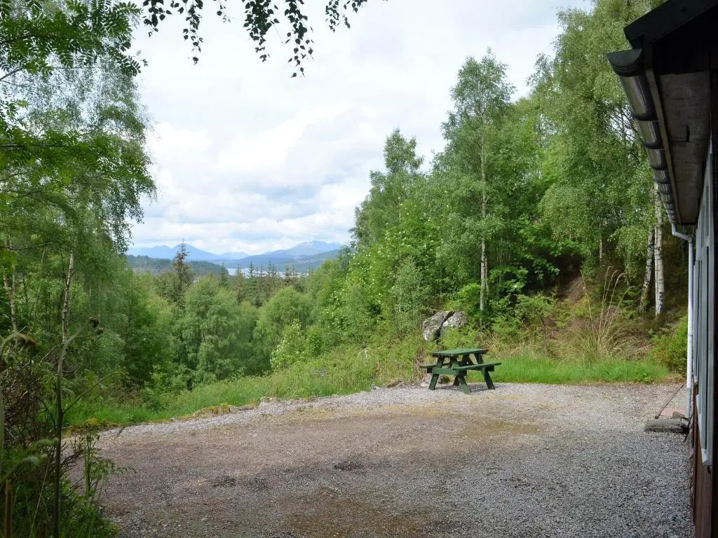 a picnic table sitting in the middle of a field at Faichemard Farm Chalets in Invergarry