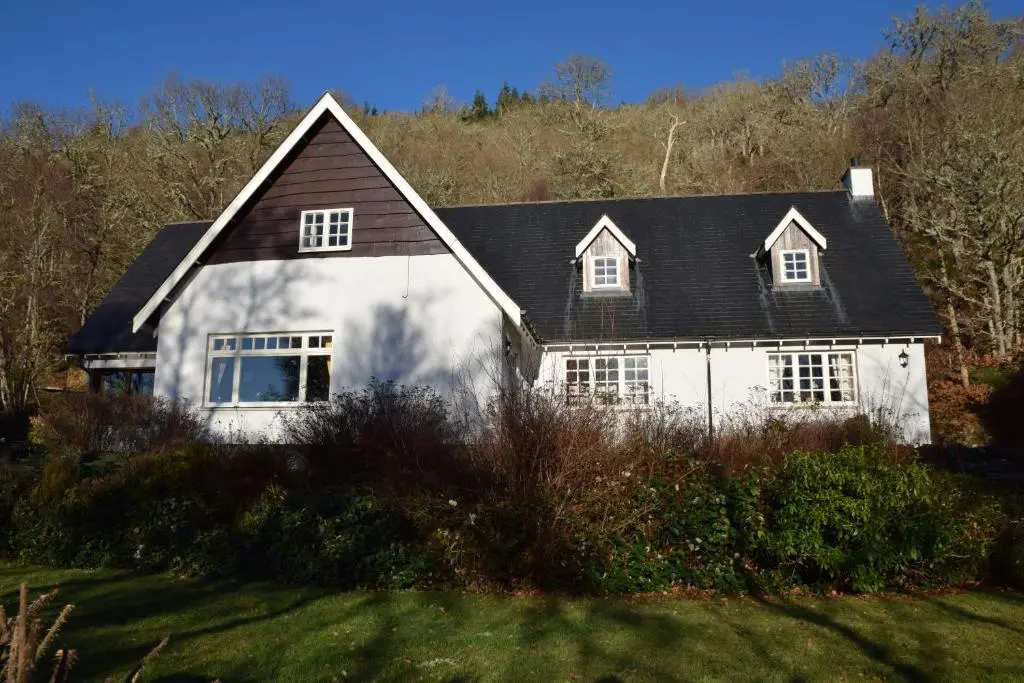 a white house with a black roof at Lochview Guesthouse in Contin