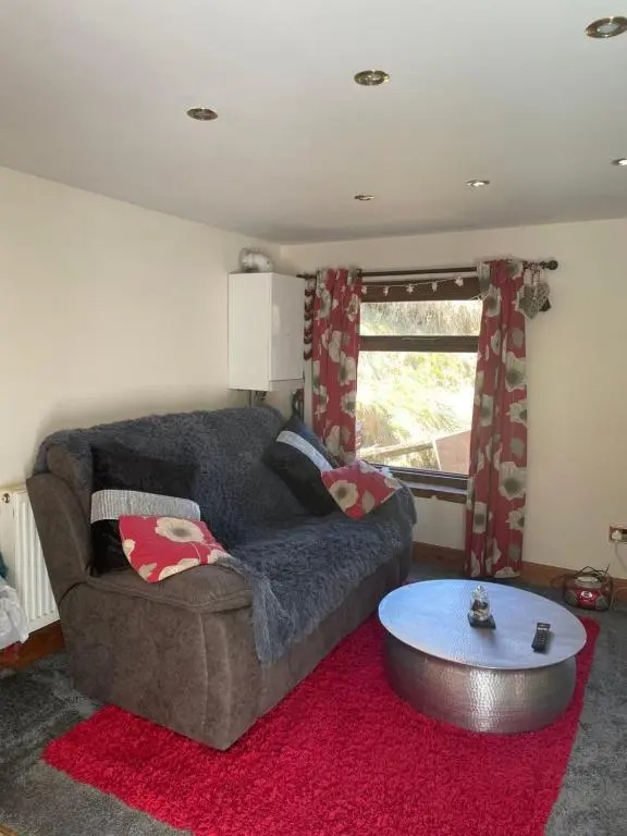 a living room with a couch and a table at Bankhead Accommodation Aberdeenshire in Gamrie