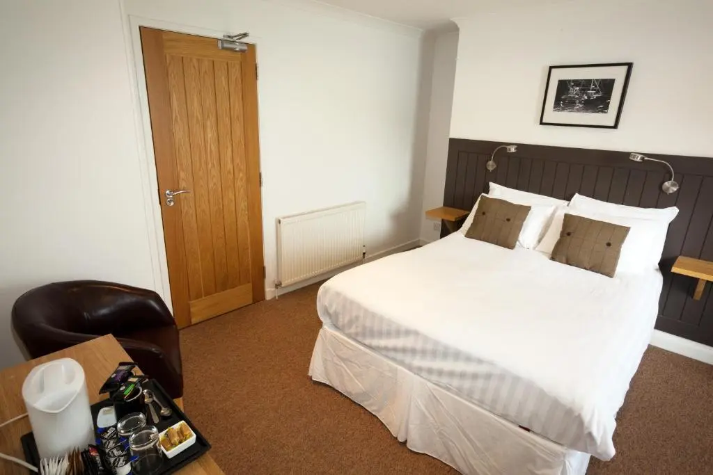 a hotel room with a bed and a desk with a camera at The Arch Inn in Ullapool