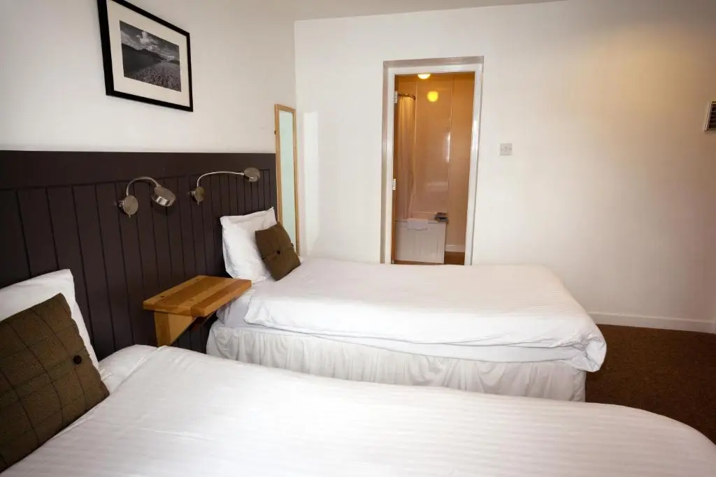 a hotel room with two beds and a mirror at The Arch Inn in Ullapool
