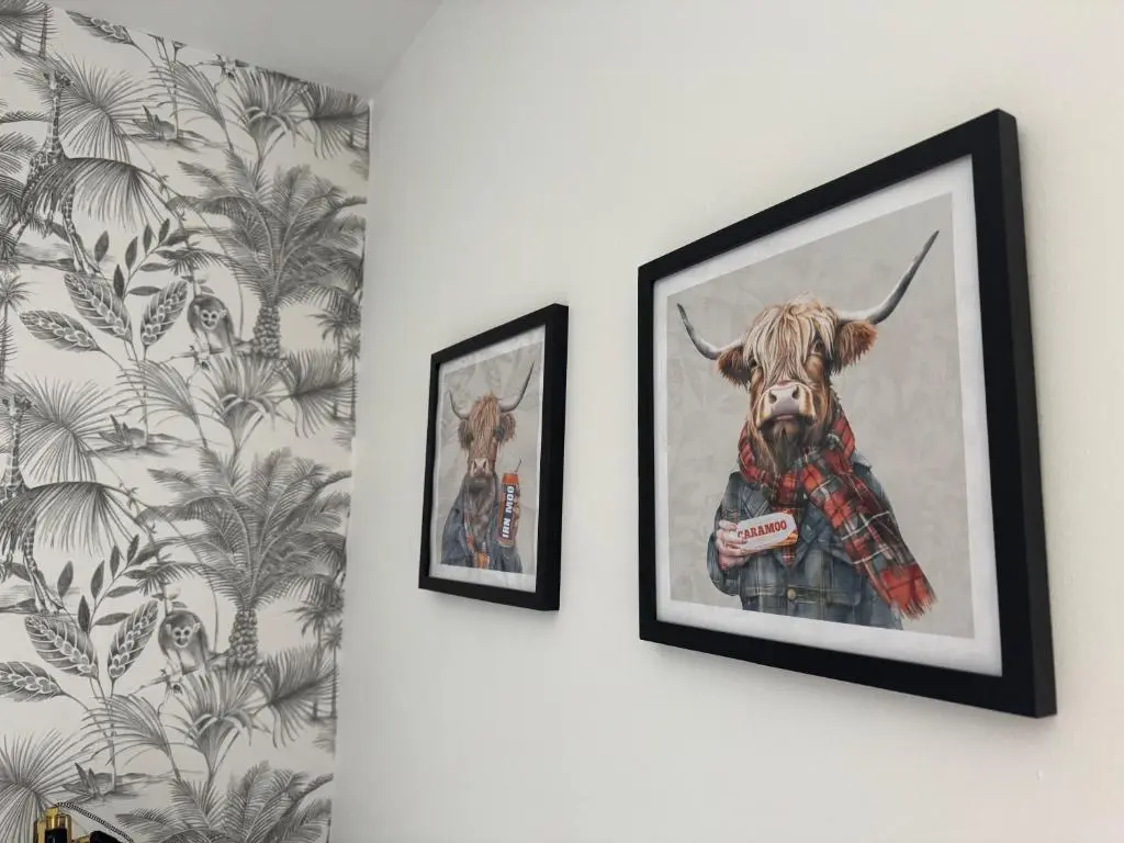 two framed pictures of a cow on a wall at The Square Kintore in Kintore
