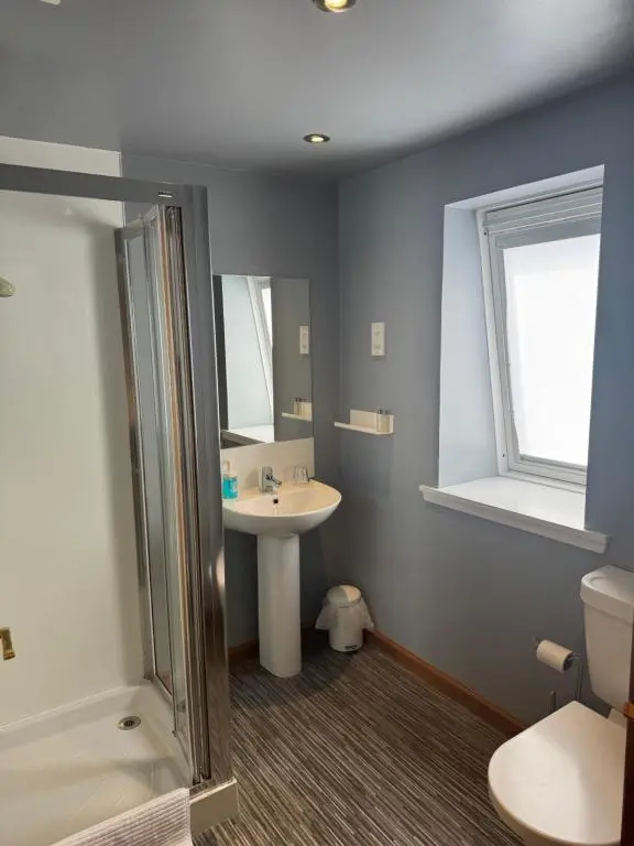 a bathroom with a sink and a shower and a toilet at The Square Kintore in Kintore