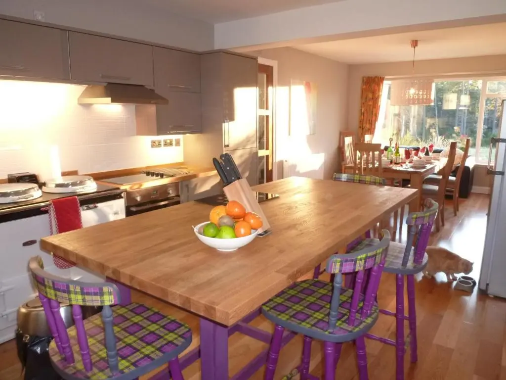 a kitchen with a wooden table with a bowl of fruit at Camusmore House in Aviemore