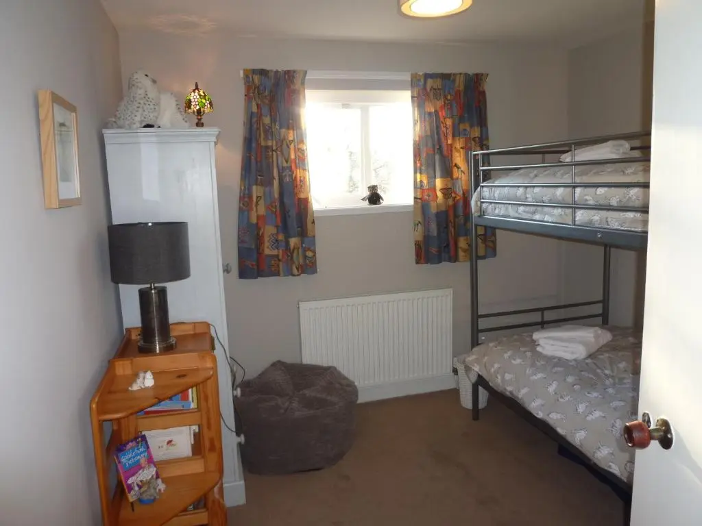 a bedroom with a bunk bed and a window at Camusmore House in Aviemore