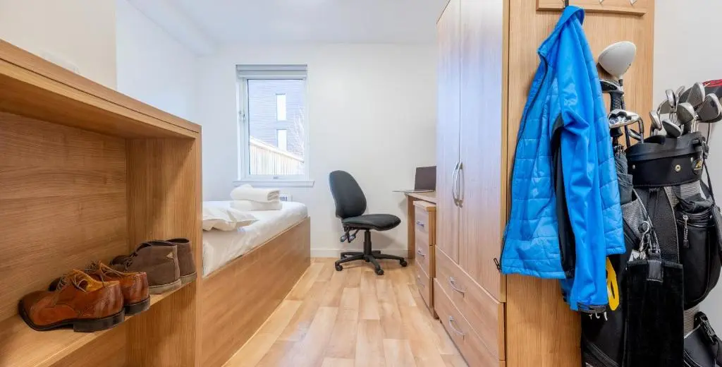 a room with a desk and a chair and shoes at UHI Inverness - Campus Accommodation in Inverness