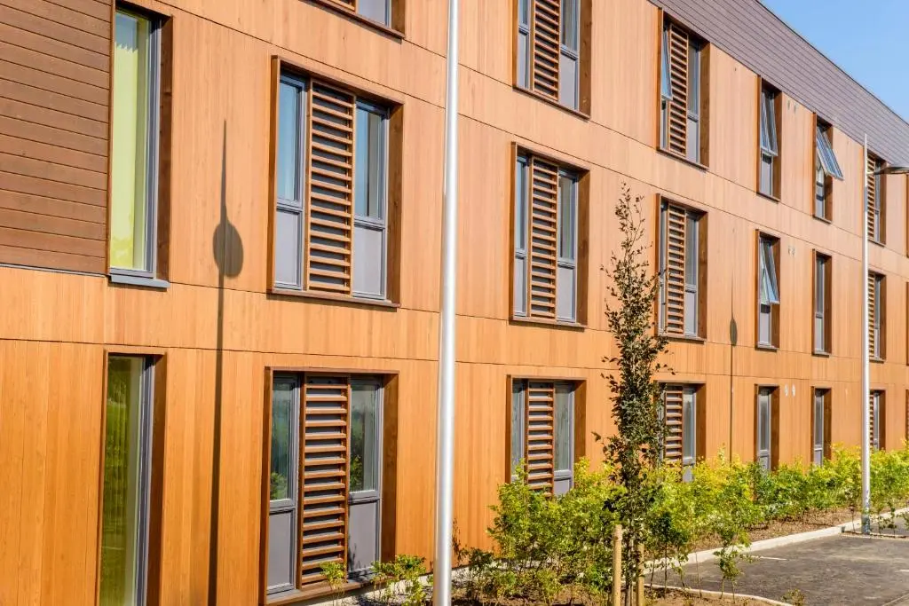 an orange building with shutters on the side of it at UHI Inverness - Campus Accommodation in Inverness