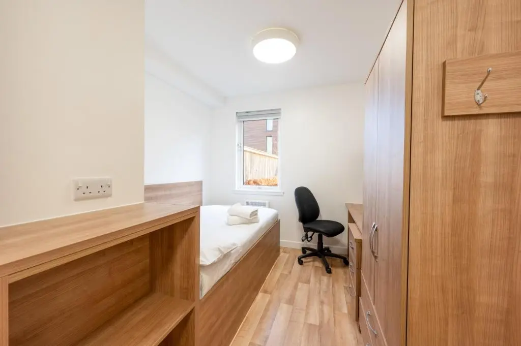 a small room with a bed and a chair at UHI Inverness - Campus Accommodation in Inverness