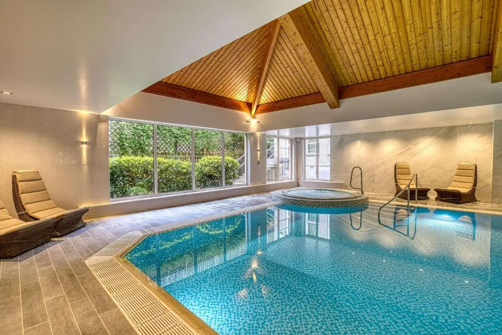 a swimming pool in a house with a large window at Inverness Palace Hotel & Spa, WorldHotels Distinctive in Inverness
