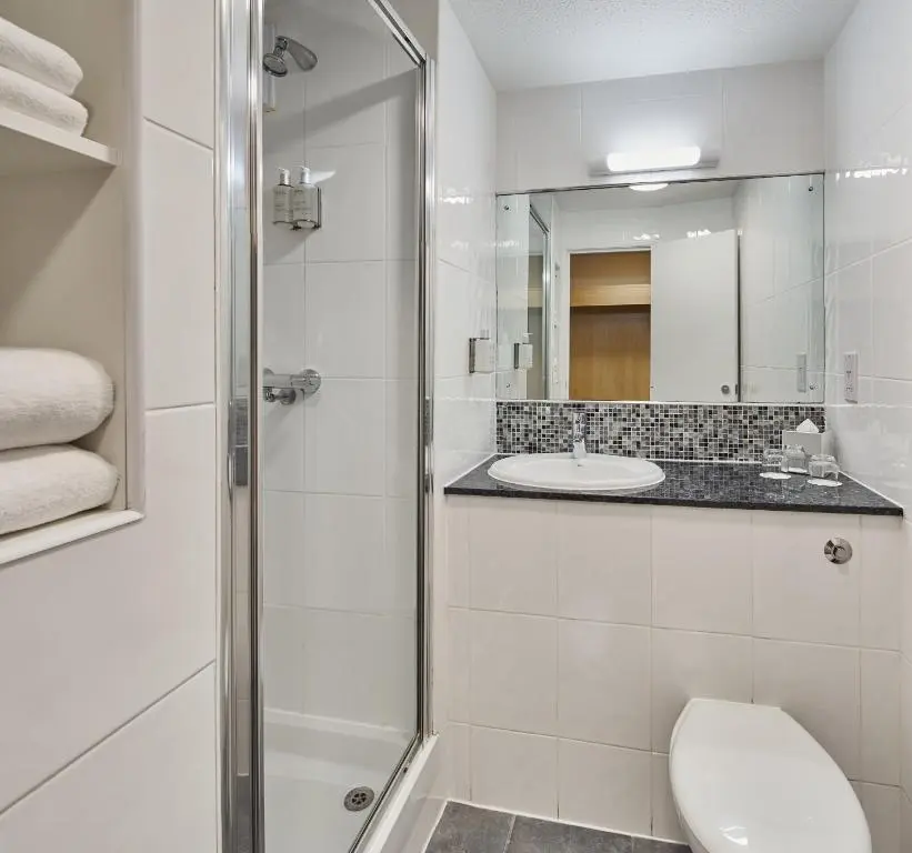 a bathroom with a shower and a toilet and a sink at Leonardo Inn Aberdeen Airport in Dyce
