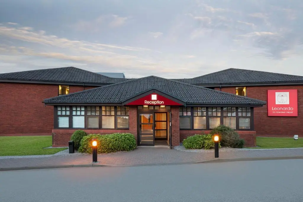 a brick building with two lights in front of it at Leonardo Inn Aberdeen Airport in Dyce