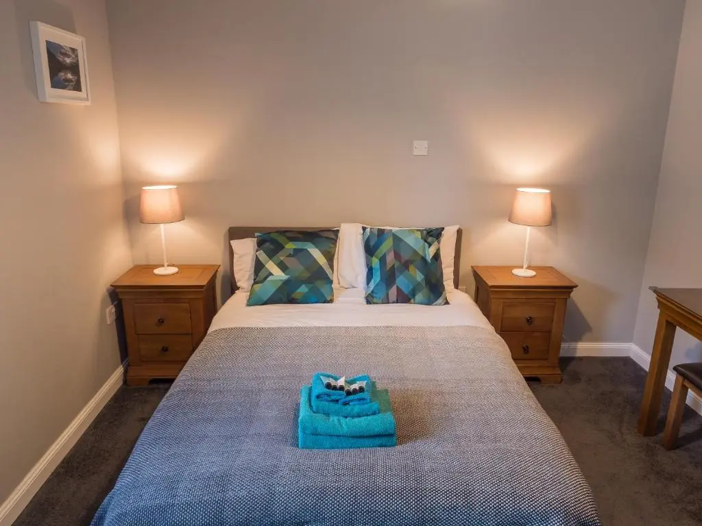 a bedroom with a bed with a blue bag on it at The Birches in Dingwall