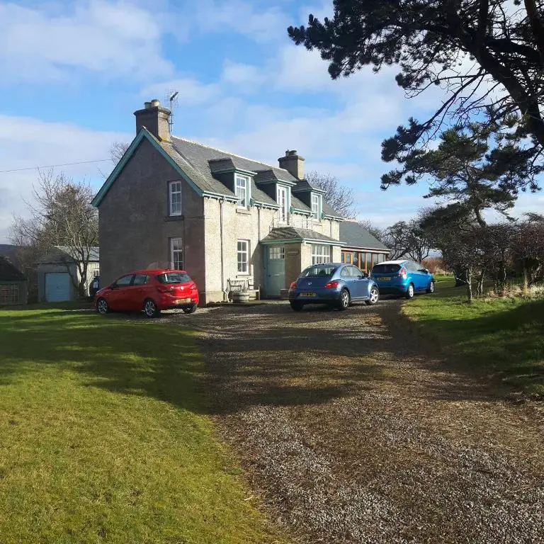 a large house with cars parked in front of it at Auchencairn Cottage in Brora